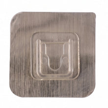 Close-up of sticky transparent wall hook installation